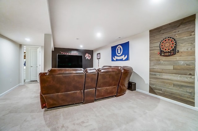 carpeted living room featuring baseboards and wood walls