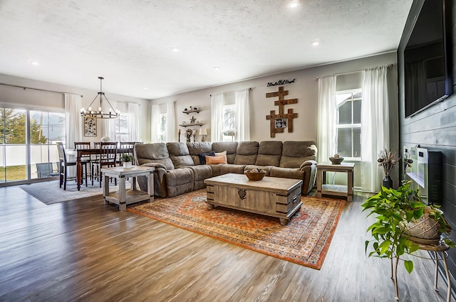 living area featuring a notable chandelier, wood finished floors, recessed lighting, and a textured ceiling