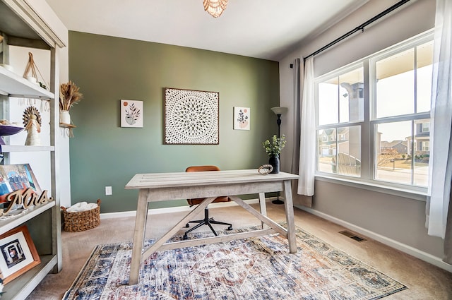 carpeted office space with baseboards and visible vents