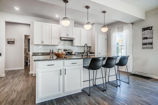 kitchen featuring a sink, decorative backsplash, dark wood-type flooring, and white cabinets