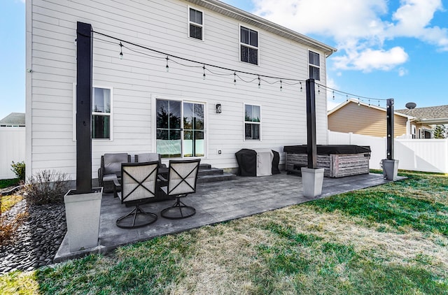 rear view of property featuring a patio area, a yard, and a fenced backyard