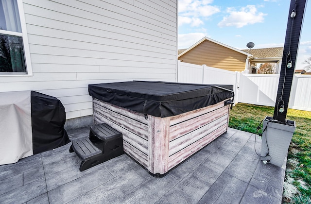 exterior space featuring fence and a hot tub