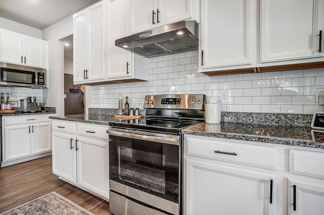 kitchen with under cabinet range hood, stainless steel appliances, wood finished floors, and white cabinetry