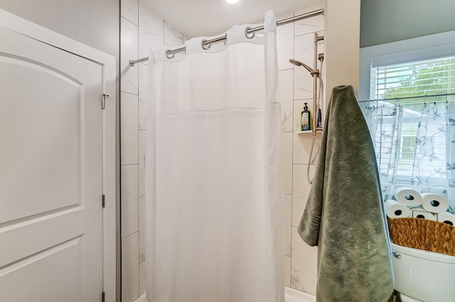 bathroom featuring shower / bath combo with shower curtain and toilet