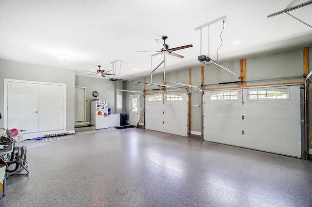 garage featuring a garage door opener, ceiling fan, and white refrigerator