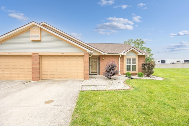 1534 Cross Pointe Cir, Bellefontaine, OH 43311 - view of front of home with brick siding, a front yard, driveway, and a garage