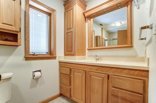 bathroom featuring baseboards, visible vents, toilet, walk in shower, and vanity