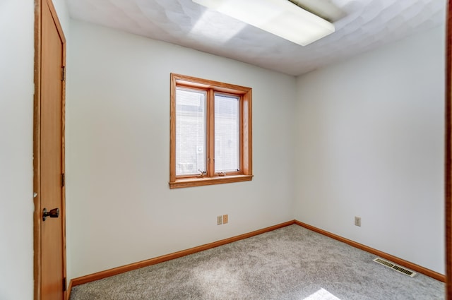 carpeted empty room featuring visible vents and baseboards