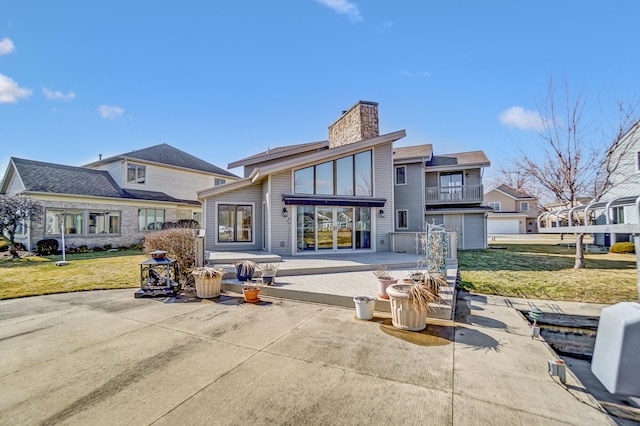 rear view of property with a deck, a residential view, a lawn, and a chimney