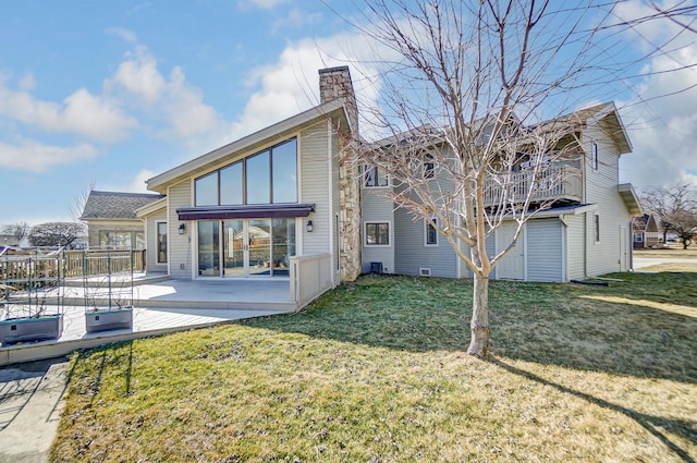 rear view of property with a patio, a chimney, and a lawn