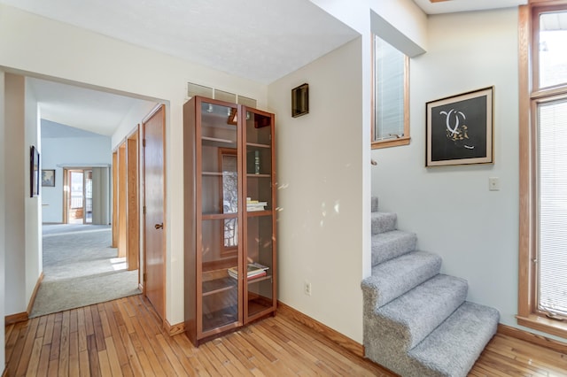 stairs featuring vaulted ceiling and hardwood / wood-style floors