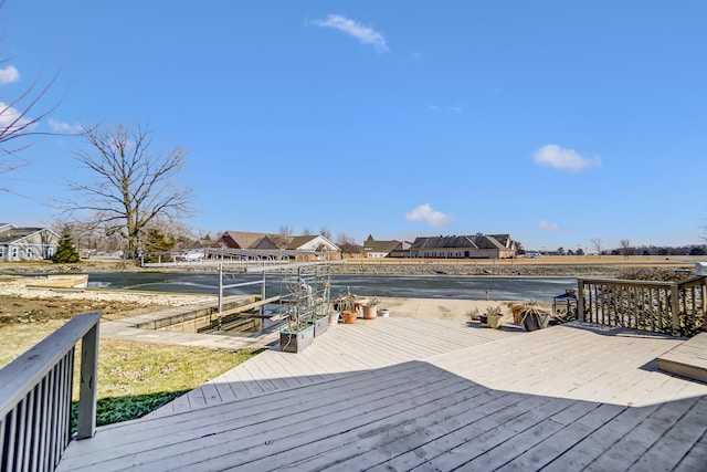 wooden terrace featuring a water view and a residential view