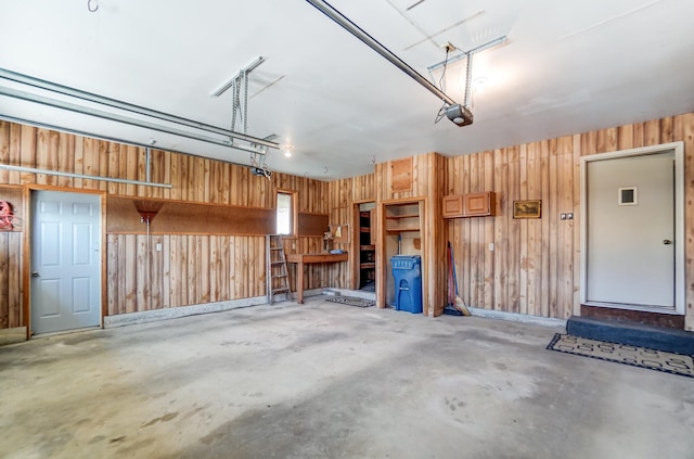 garage with a garage door opener and wood walls