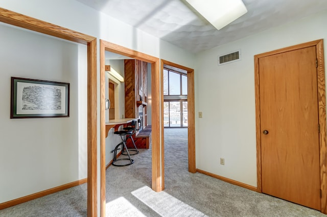 interior space featuring light colored carpet, visible vents, and baseboards