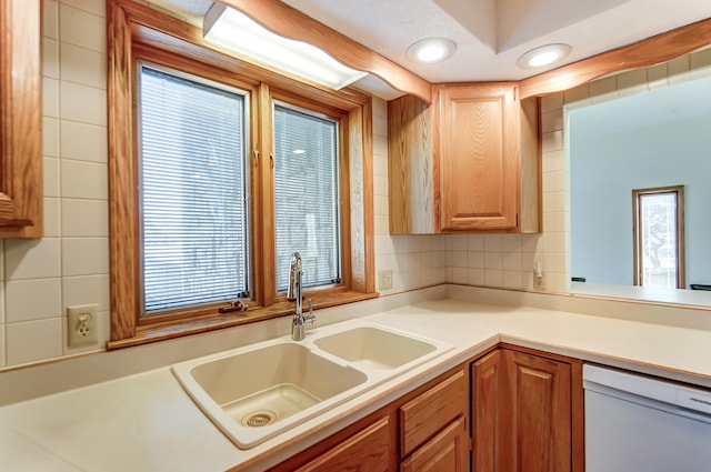 kitchen with a wealth of natural light, light countertops, dishwasher, and a sink