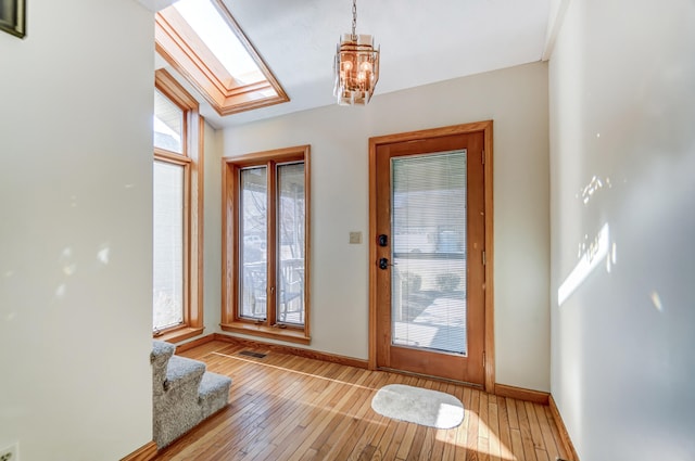 entryway featuring visible vents, baseboards, stairway, and light wood finished floors