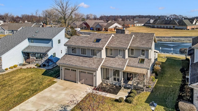 view of front of house with concrete driveway, a front lawn, an attached garage, and a residential view