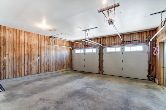 garage with wood walls and a garage door opener