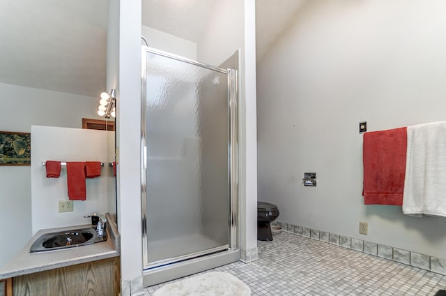 bathroom featuring a sink, tile patterned flooring, a shower stall, and toilet