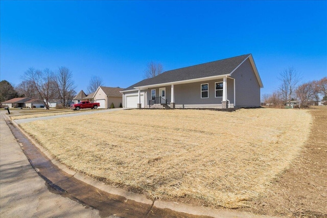 ranch-style house featuring driveway, covered porch, and an attached garage