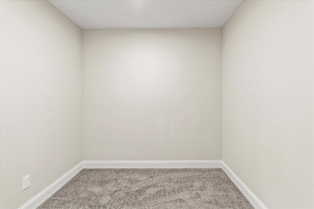 carpeted empty room featuring baseboards