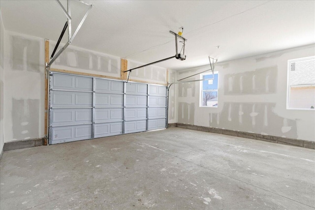 garage featuring a garage door opener and baseboards