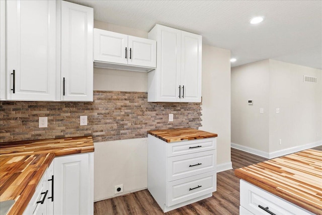 kitchen with decorative backsplash, wood finished floors, visible vents, and wood counters