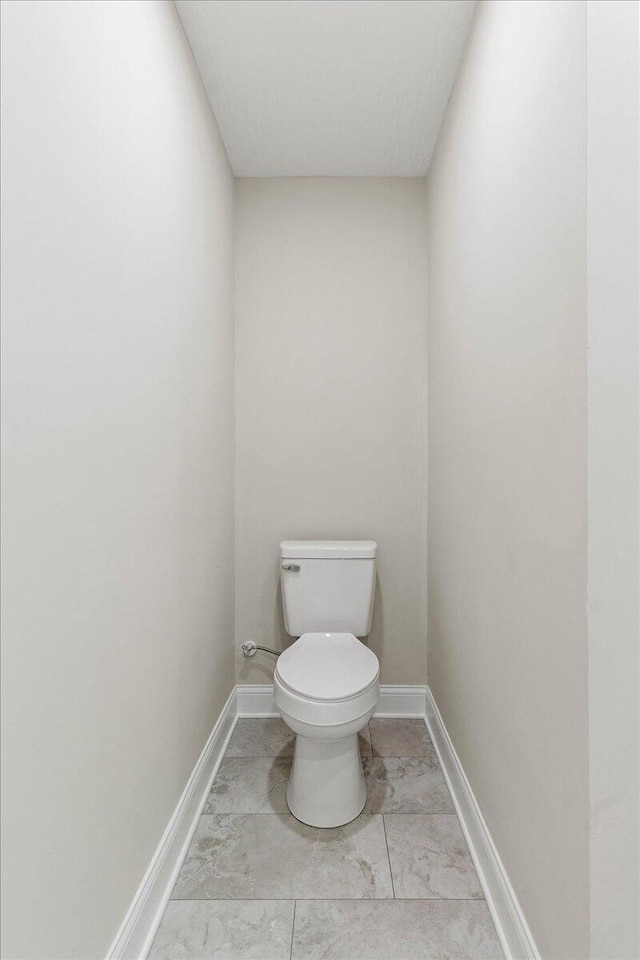 bathroom with baseboards and toilet