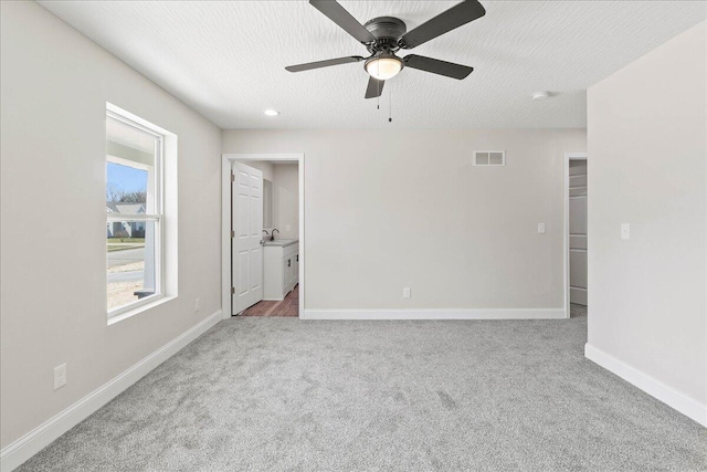 carpeted empty room featuring visible vents, ceiling fan, baseboards, recessed lighting, and a textured ceiling