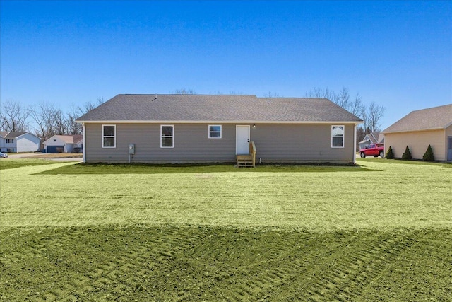 back of house with entry steps and a yard