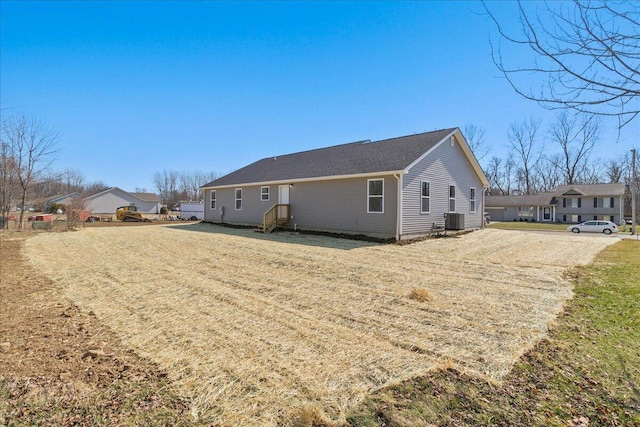 back of house featuring cooling unit and a lawn