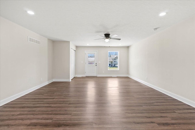 unfurnished living room with visible vents, a ceiling fan, dark wood-style floors, recessed lighting, and baseboards