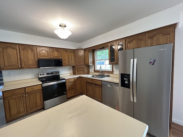 5151 Pheasant St, Lima, OH 45807 - kitchen with appliances with stainless steel finishes, glass insert cabinets, tasteful backsplash, and light countertops