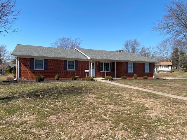 ranch-style house featuring brick siding and a front lawn