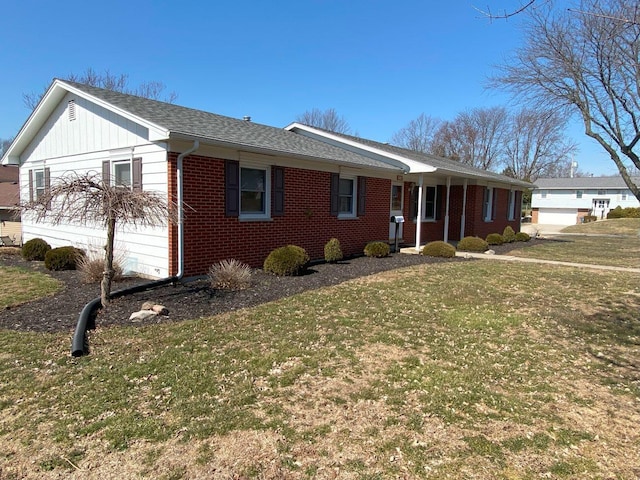 view of front of property with brick siding, a shingled roof, and a front lawn