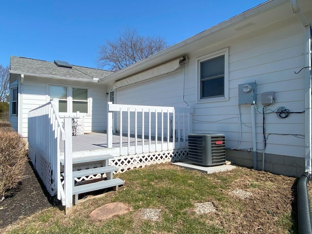 rear view of house with a wooden deck, roof with shingles, and central AC unit