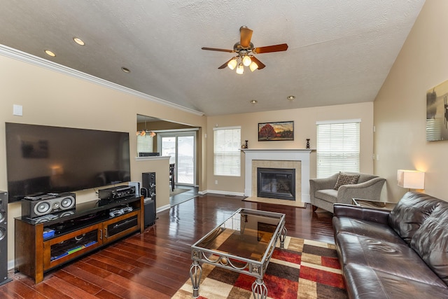 living room with a tiled fireplace, a ceiling fan, a textured ceiling, and wood finished floors