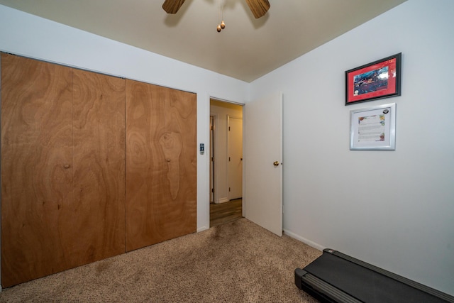 exercise room with a ceiling fan and carpet flooring