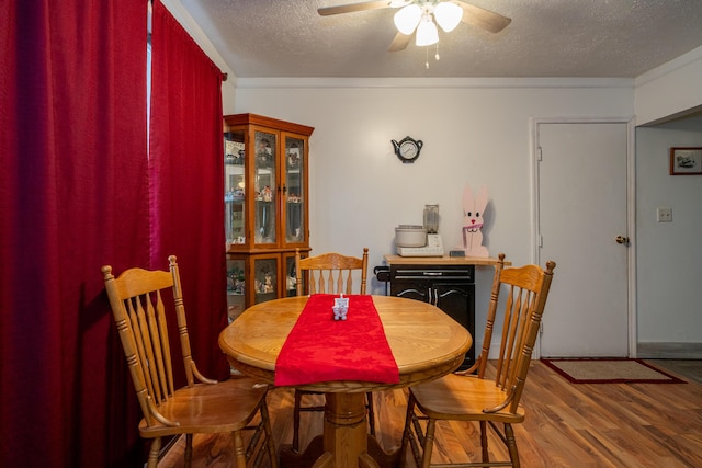 dining area featuring ceiling fan, a textured ceiling, and wood finished floors