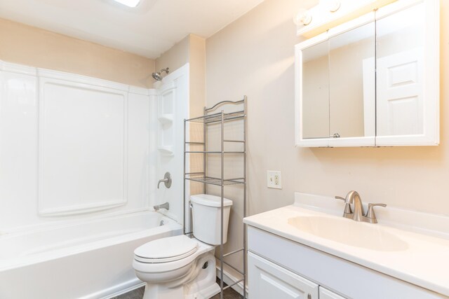 bathroom featuring toilet, vanity, and bathtub / shower combination