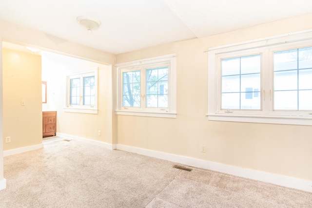 unfurnished room featuring carpet and baseboards