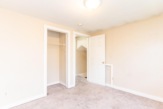 unfurnished bedroom with carpet flooring, a closet, and baseboards