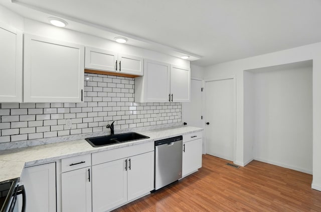 kitchen with white cabinetry, tasteful backsplash, a sink, visible vents, and dishwasher