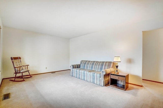 sitting room featuring carpet floors, visible vents, and baseboards