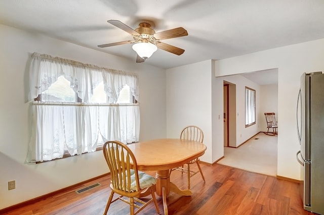 dining area featuring ceiling fan, light wood-style flooring, visible vents, and baseboards