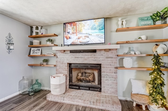 details with a fireplace, a textured ceiling, baseboards, and wood finished floors