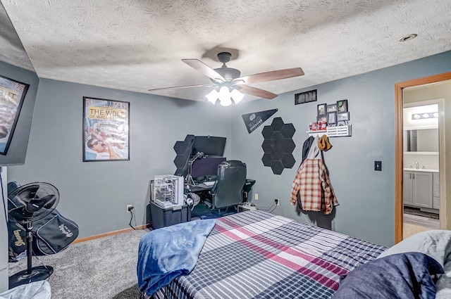 carpeted bedroom with ceiling fan, baseboards, and a textured ceiling