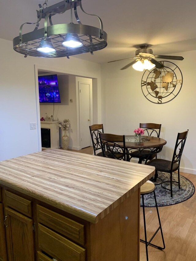 6645 Oak Dr, Celina, OH 45822 - kitchen with light wood-style flooring, wood counters, ceiling fan, and a breakfast bar area