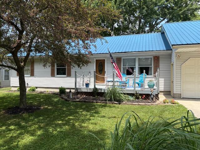 6645 Oak Dr, Celina, OH 45822 - view of front of property featuring covered porch, a garage, a front lawn, a metal roof, and concrete driveway