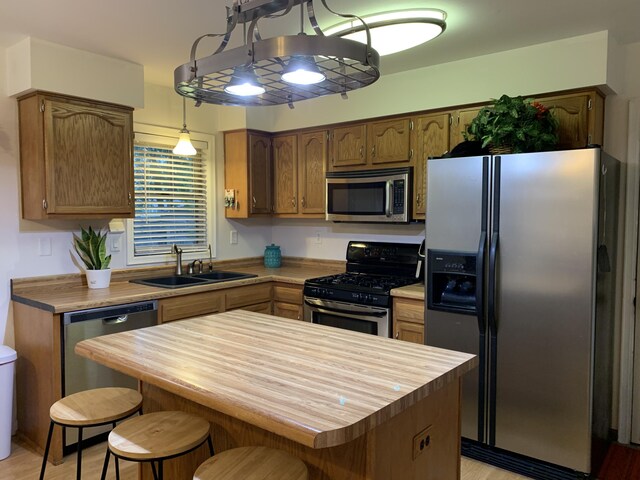 6645 Oak Dr, Celina, OH 45822 - kitchen with appliances with stainless steel finishes, wood counters, pendant lighting, a breakfast bar area, and light wood-type flooring